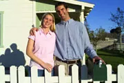 happy couple near fenced in home